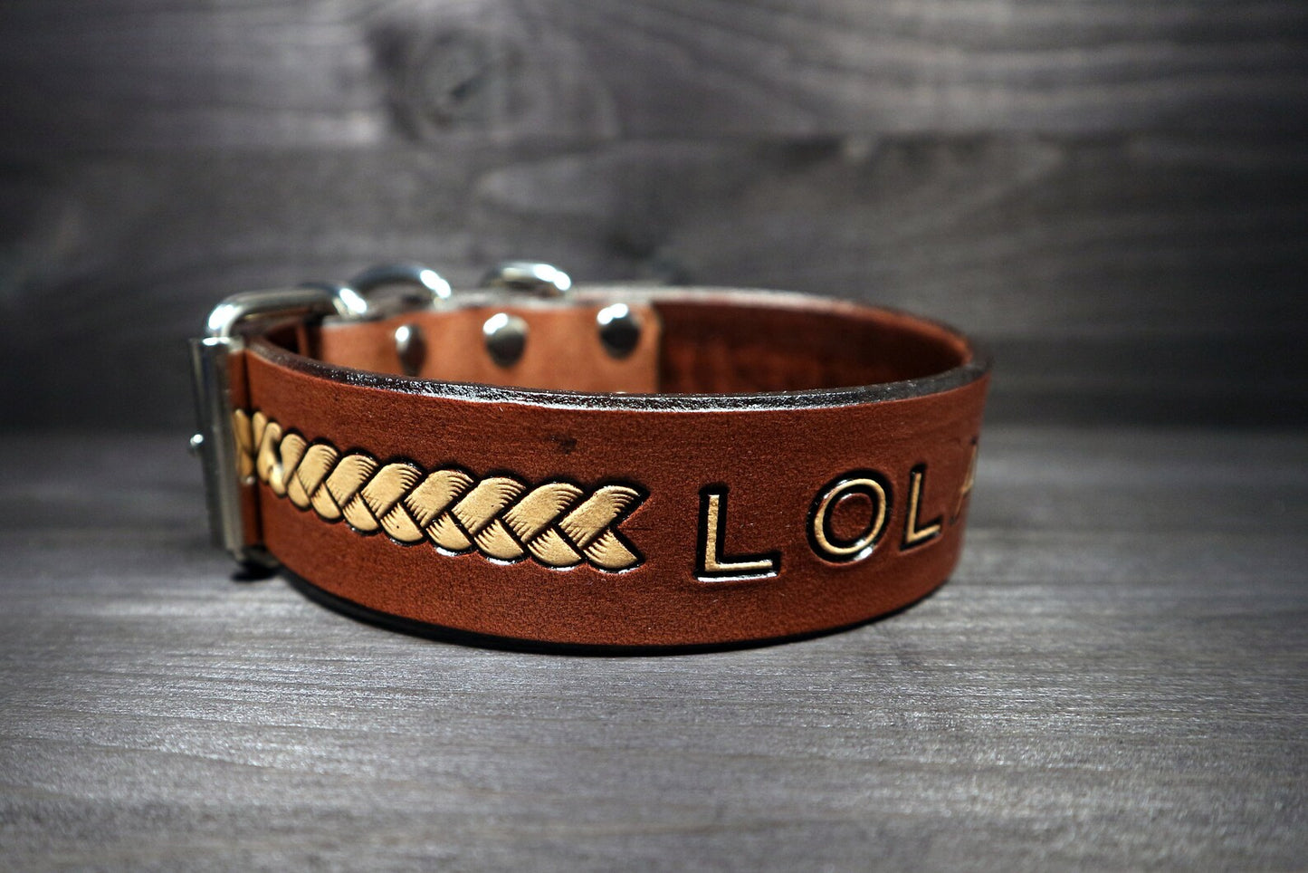 Detail koženého obojku pro psa s basket ražbou a vyraženým jménem Lola