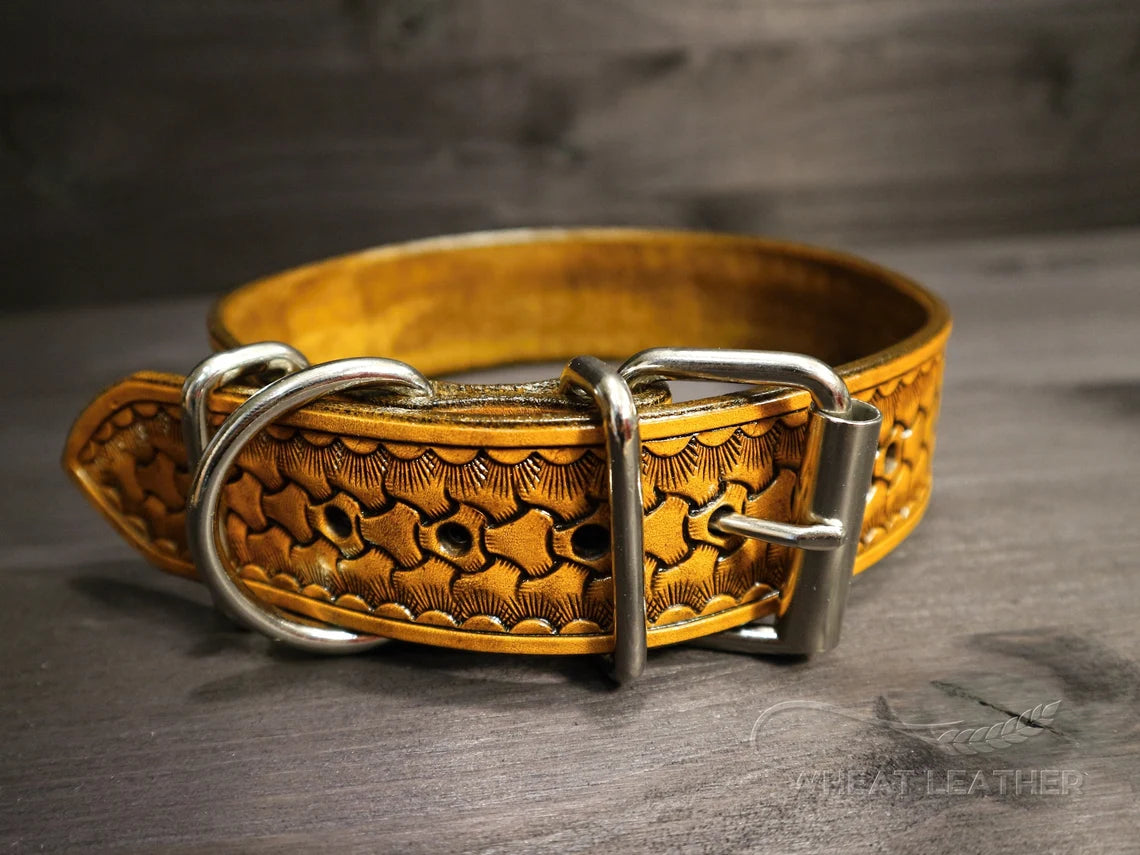 Detail koženého obojku pro psa s masivní kovovou přezkou, D-kroužkem na vodítko a ručně raženým vzorem